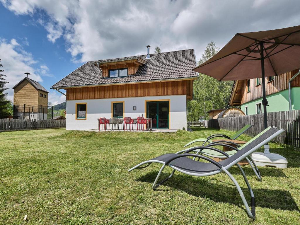 een paar ligstoelen en een parasol voor een huis bij Chalet Murtal XL in Sankt Michael im Lungau