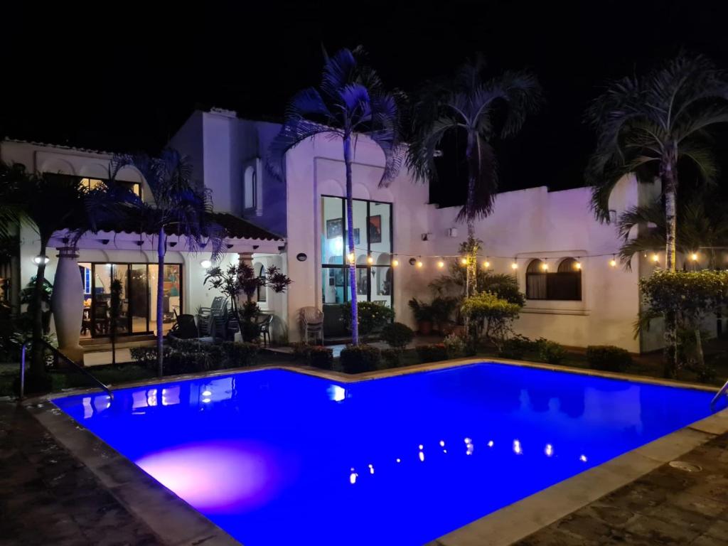 a swimming pool in front of a house at night at Casa del Arte, a luxury beachfront villa with private pool in Tela