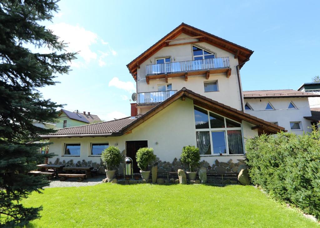 uma casa grande com uma varanda em cima em Pensjonat Tara em Jeleśnia