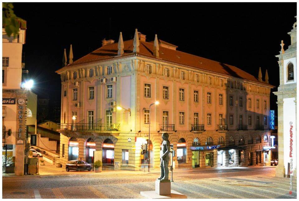 um grande edifício com uma estátua em frente em Hotel Solneve na Covilhã