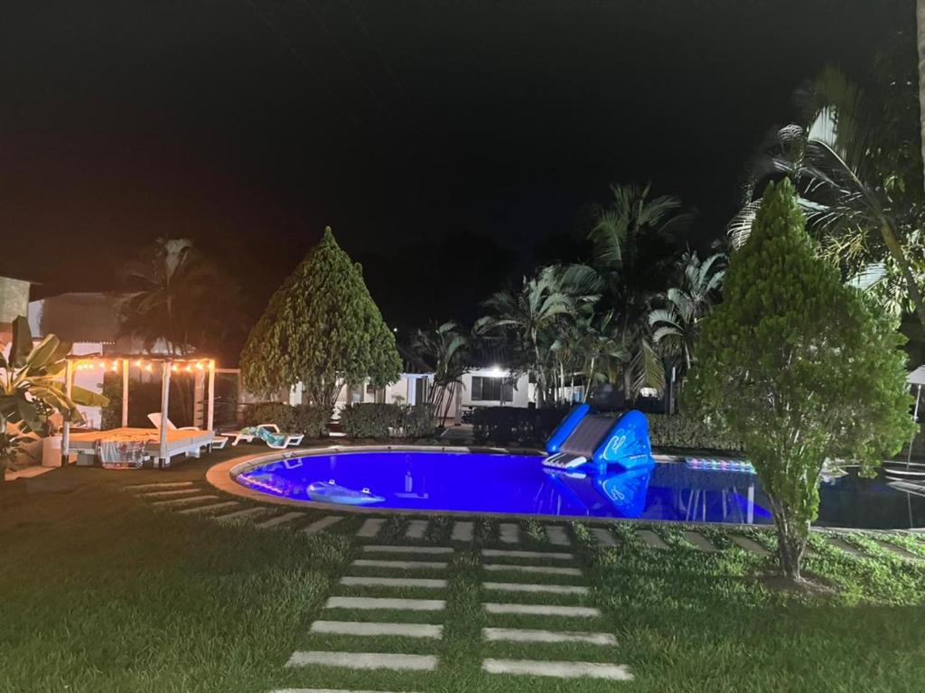 a swimming pool in a yard at night at Villa Tarek in Carmen de Apicalá