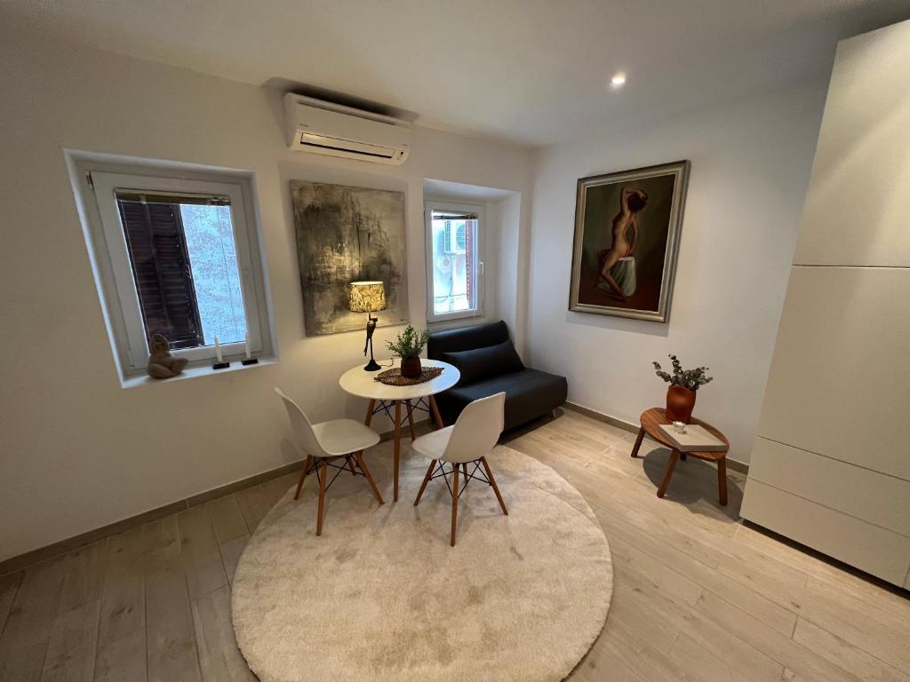 een woonkamer met een tafel en stoelen en een bank bij Noelle apartment in Rovinj