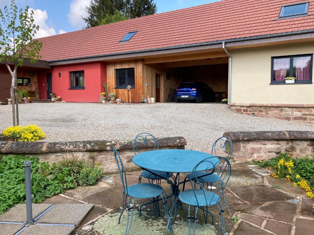 een tafel en stoelen voor een garage bij Le Noyer in Cosswiller