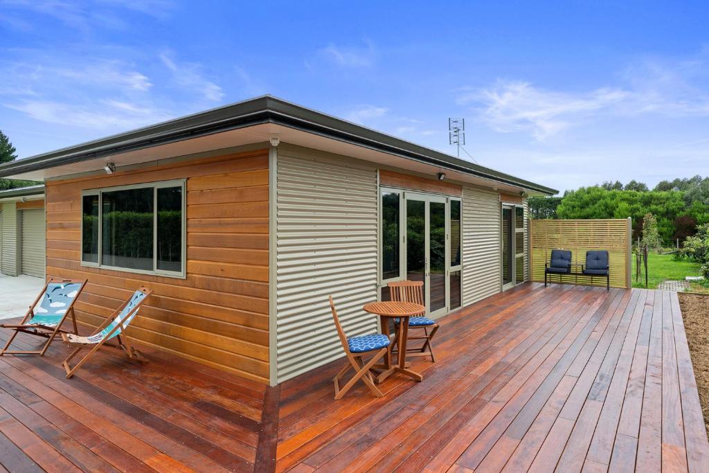 een huis met een terras met stoelen en een tafel bij Orange Blossom Cottage - Greytown Holiday Home in Greytown