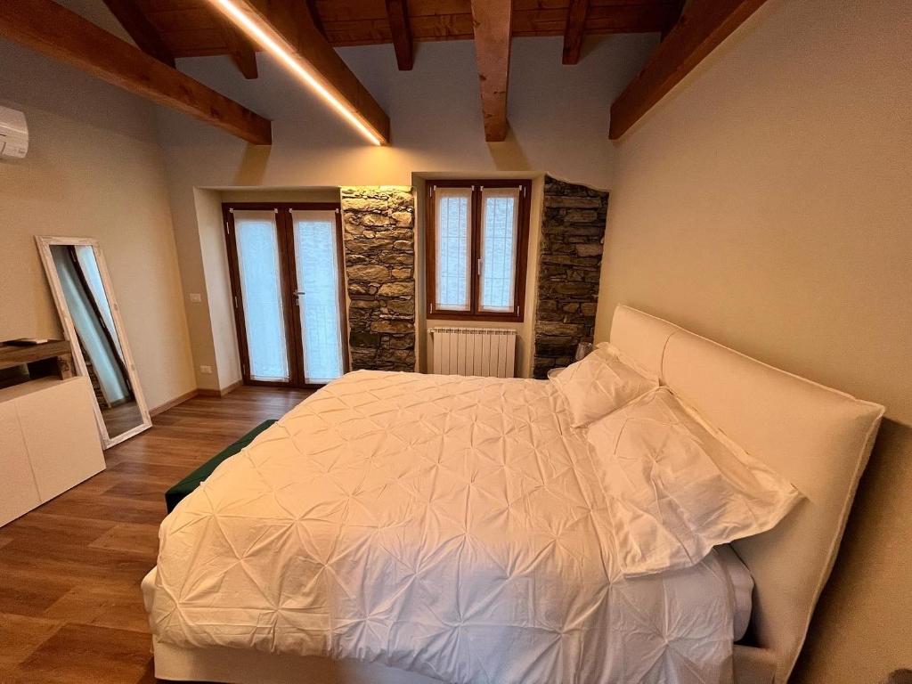 a bedroom with a white bed in a room at Bed & Bike La Stalla in Masera