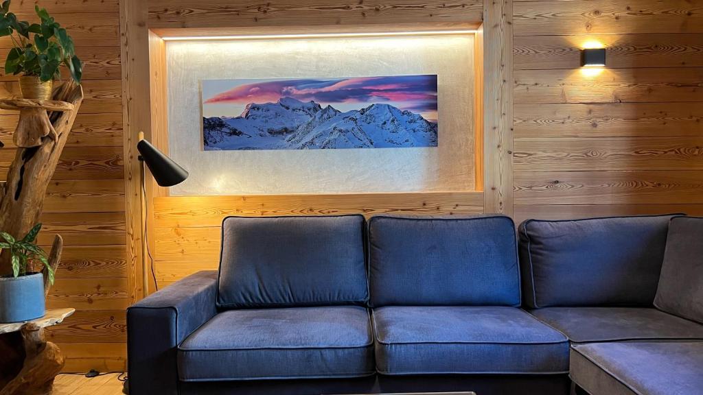 a living room with a couch and a picture at Hotel Les Chamois in Verbier