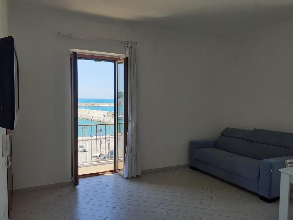 a living room with a couch and a view of the ocean at TAGLIAMENTO APARTMENT in Vieste