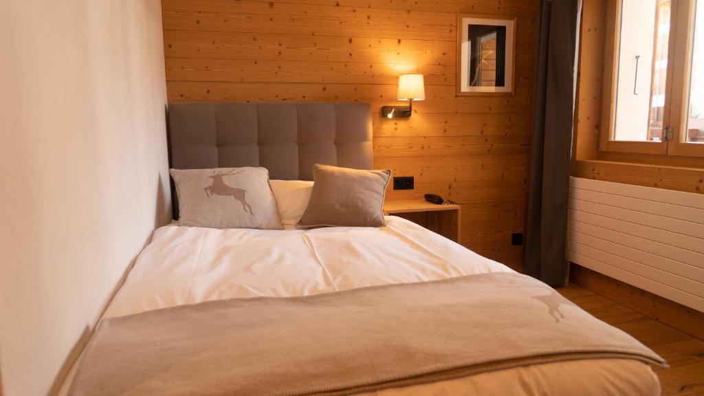 a bedroom with a large bed in a wooden room at Hotel Les Chamois in Verbier