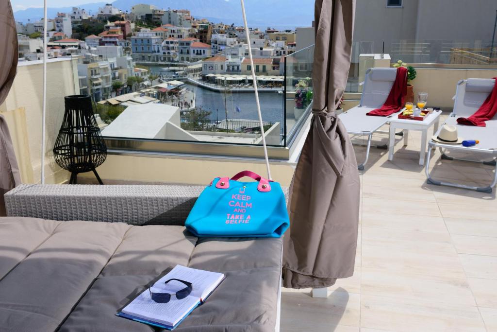 a blue bag sitting on a couch on a balcony at Luxury Lake View Center House in Agios Nikolaos