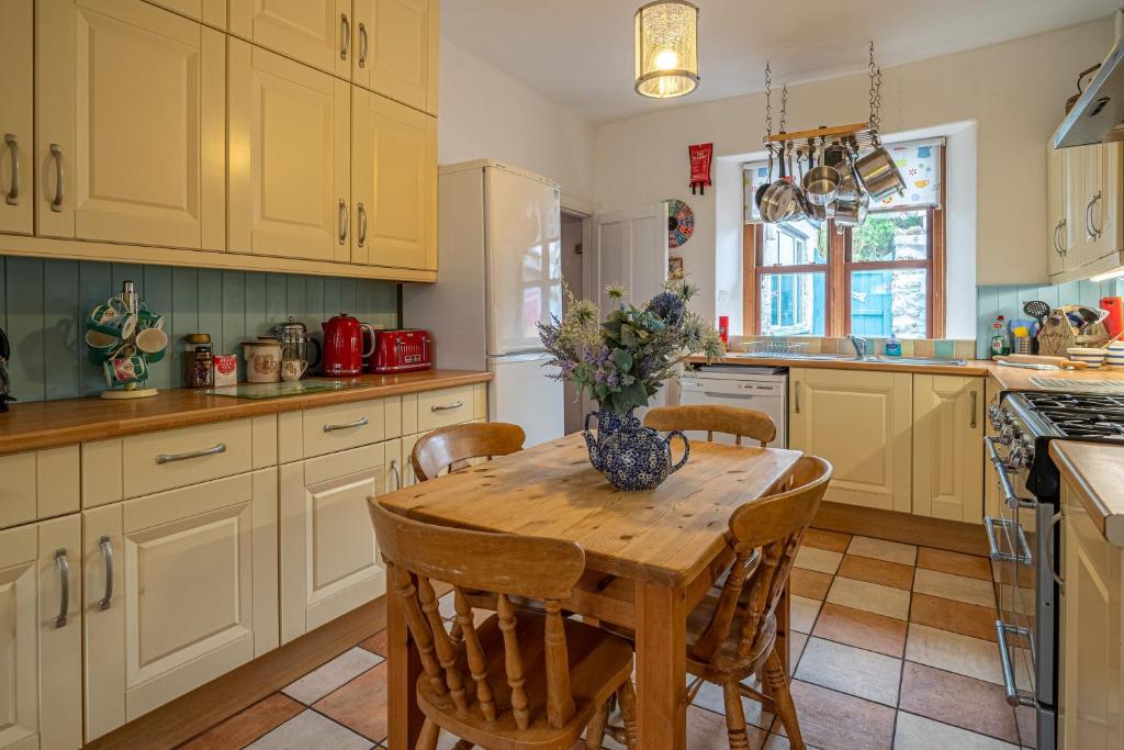 a kitchen with a wooden table and chairs at The Old Post Office in Grange Over Sands
