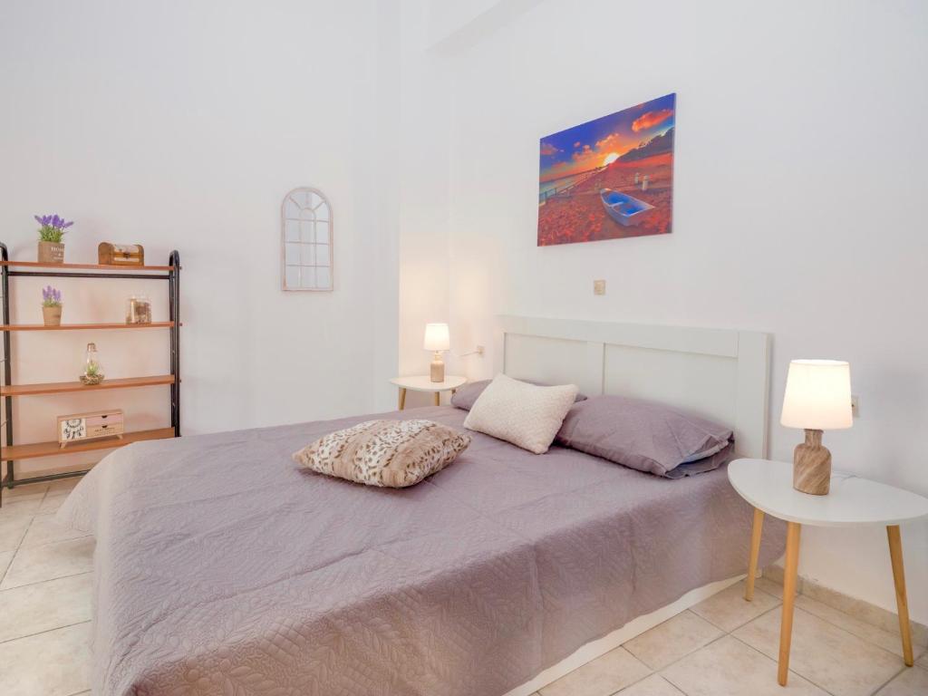 a bedroom with a bed and a table and a painting at fam central apt in Heraklio Town
