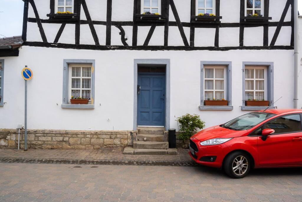 un coche rojo estacionado frente a una casa blanca en 3 Zimmer Wohnung in Bechtolsheim max. 5 Personen en Bechtolsheim