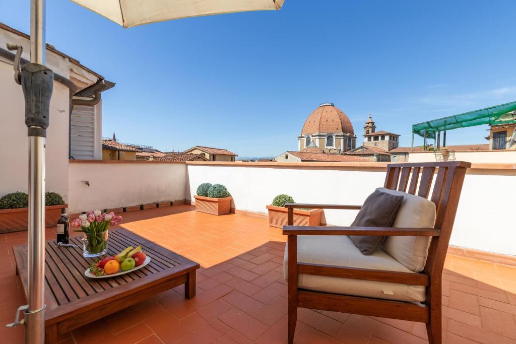 een balkon met een stoel en een tafel met fruit bij Damasco penthouse with terrace near the Duomo in Florence