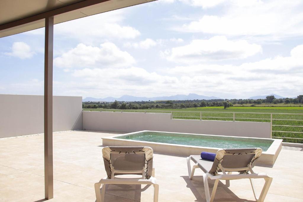 - deux chaises sur une terrasse avec piscine dans l'établissement AGROTURISMO SARAIX, à Santa Margalida