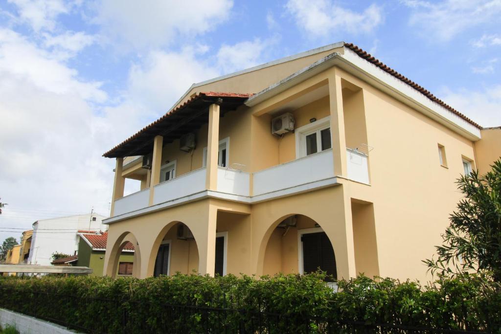 une maison jaune avec un blanc dans l'établissement Corfu-Apartments4you, à Acharavi