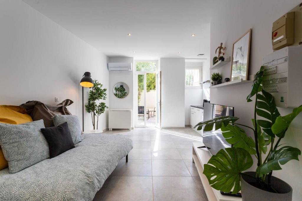 un salon avec un canapé et une plante dans l'établissement MaxBnb - CLIMATISÉ - T2 37m2 & terrasse 30m2 - Est, à Toulon