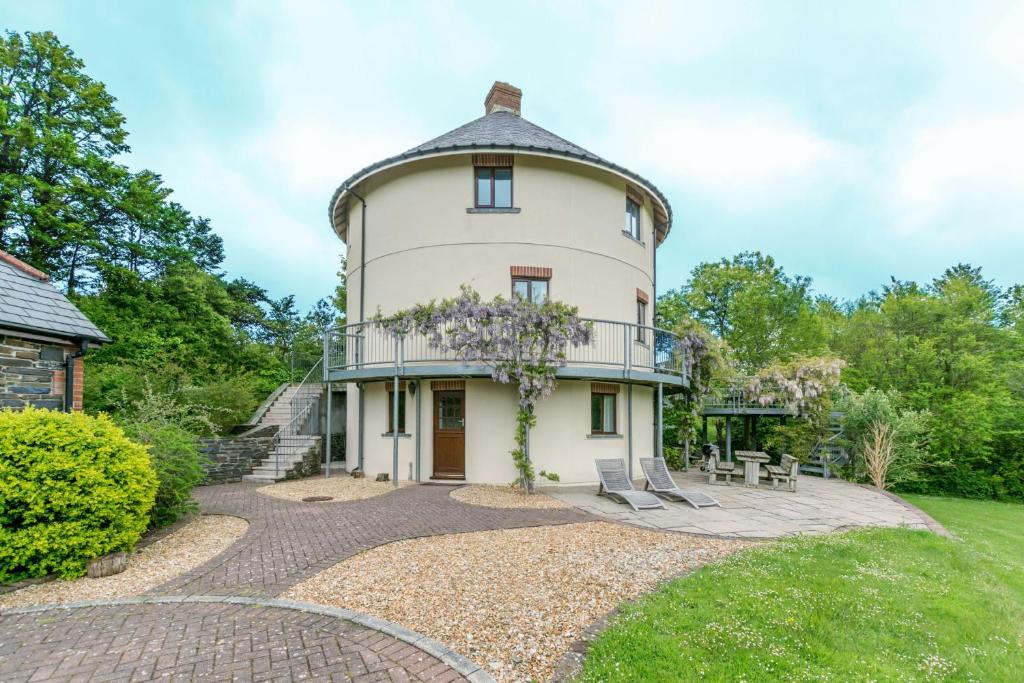 uma casa com uma torre redonda com um telhado em The Roundhouse em Wadebridge