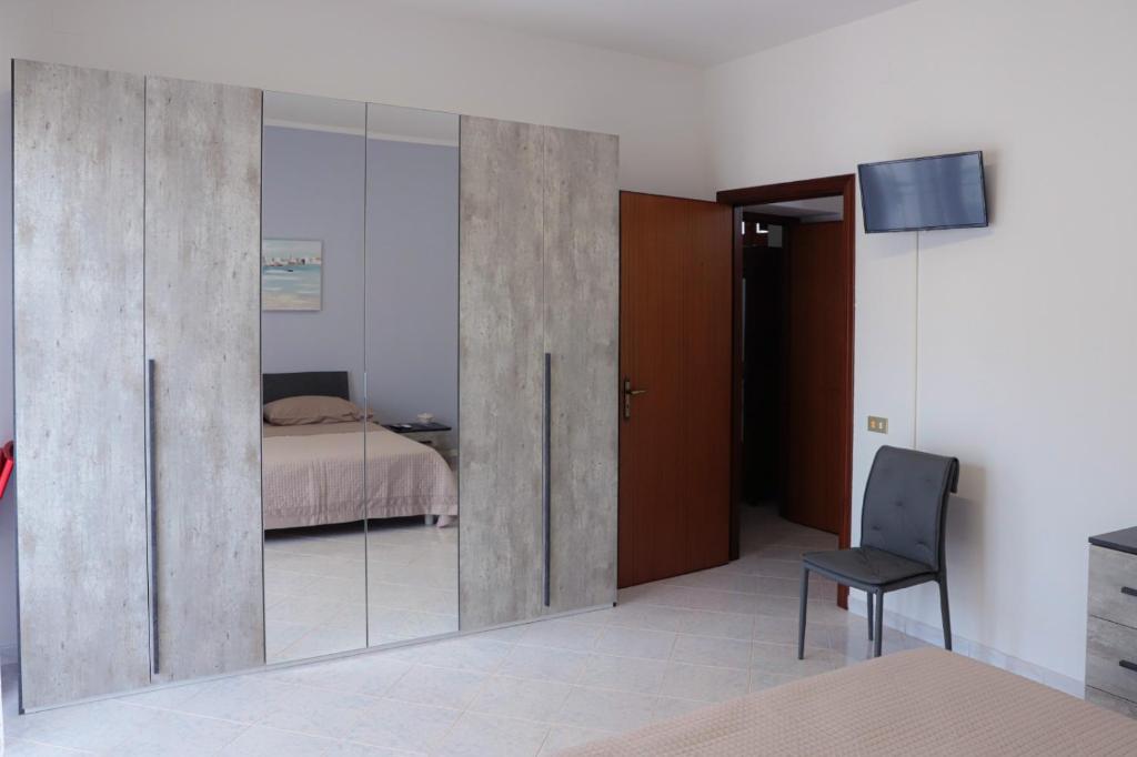 sypialnia z przesuwnymi szklanymi drzwiami i łóżkiem w obiekcie B&B LA CASA DEI FIORI w mieście Amorosi