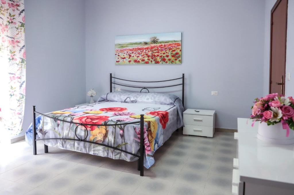 AmorosiにあるB&B LA CASA DEI FIORIのベッドルーム1室(壁に絵画が描かれたベッド1台付)