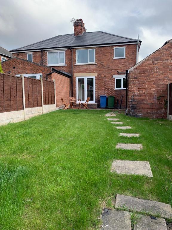 a brick house with a green lawn in front of it at Worksop Newly Refurbished 2-Bedroom House in Worksop