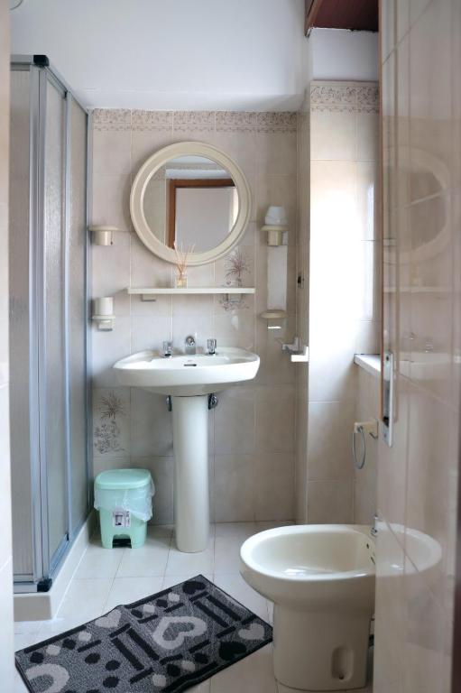łazienka z umywalką, toaletą i lustrem w obiekcie B&B LA CASA DEI FIORI w mieście Amorosi