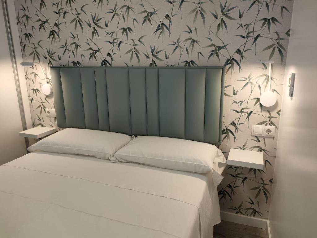 a bedroom with a bed with a green headboard at Beach front Esther 5 villajoyosa in Villajoyosa