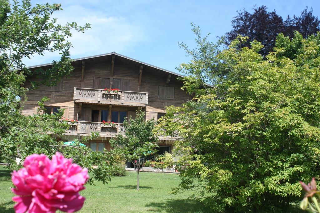 ein Haus mit einem Balkon und einer rosa Blume in der Unterkunft Résidence Chalet des Granges in Samoëns