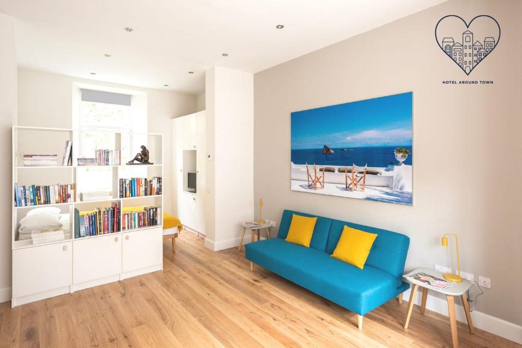 een woonkamer met een blauwe bank en een boekenplank bij Artist's Studio in Stockbridge in Edinburgh