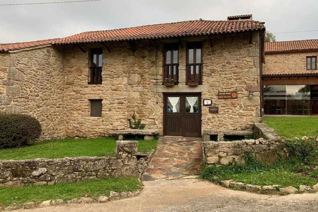 a stone house with a door in a yard at Casa Rural, Casal do Mouro in A Coruña