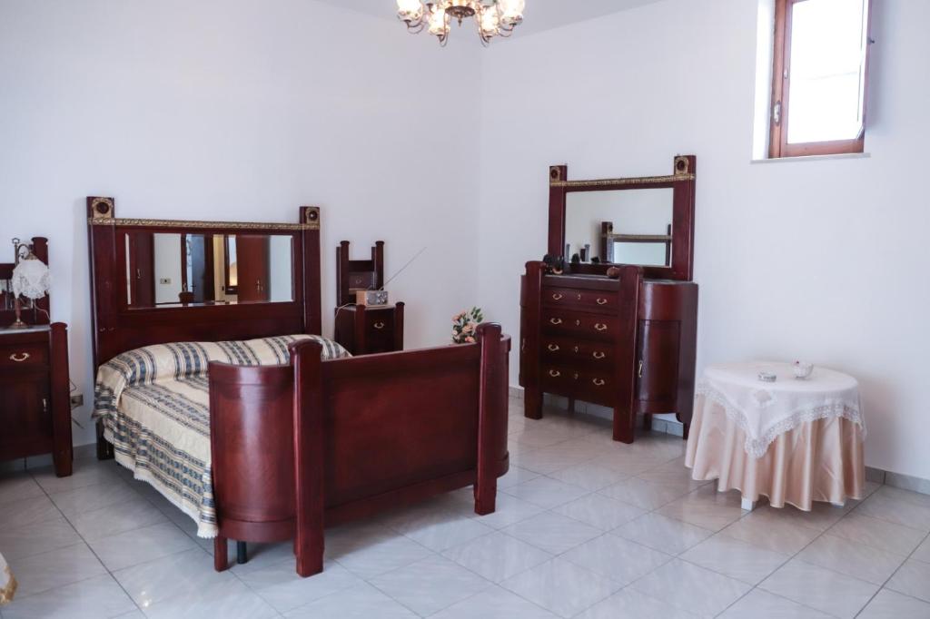 Pokój z 2 lustrami, łóżkiem i stołem w obiekcie B&B LA CASA DEI FIORI w mieście Amorosi