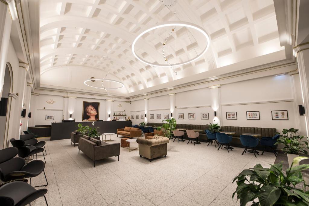 a large lobby with chairs and tables and a woman at The Gold Bank in Prague