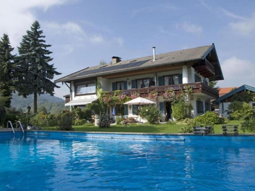 a house with a swimming pool in front of it at Appartement Bergblick in Grassau
