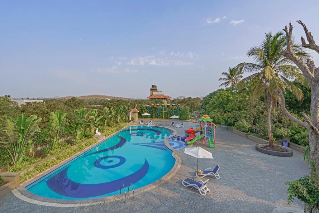 a swimming pool with a slide and a playground at Sterling Gir in Sasan Gir