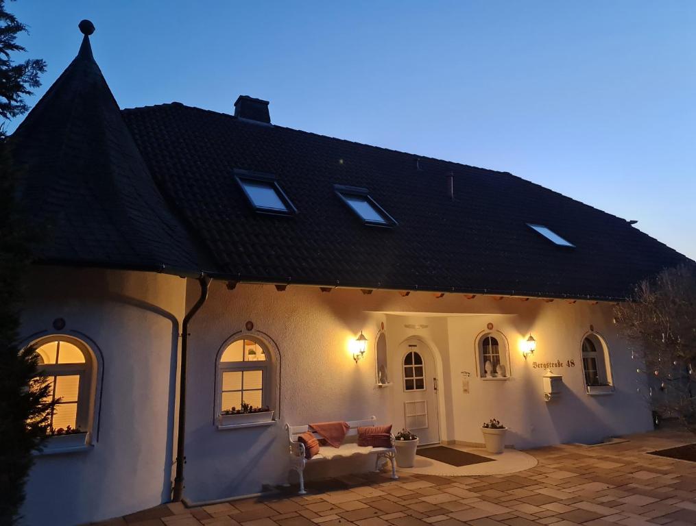 una gran casa blanca con techo negro en GardenView Apartments & Suites bei Bad Kissingen, en Nüdlingen