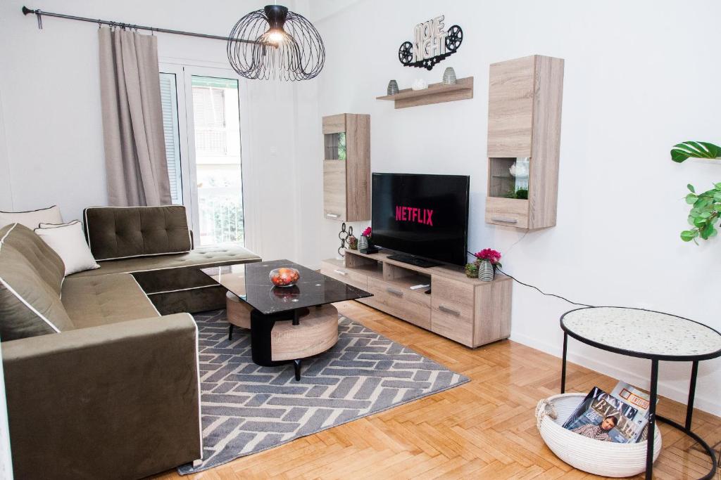 a living room with a couch and a tv at Elegant apt in Kifisia! in Athens
