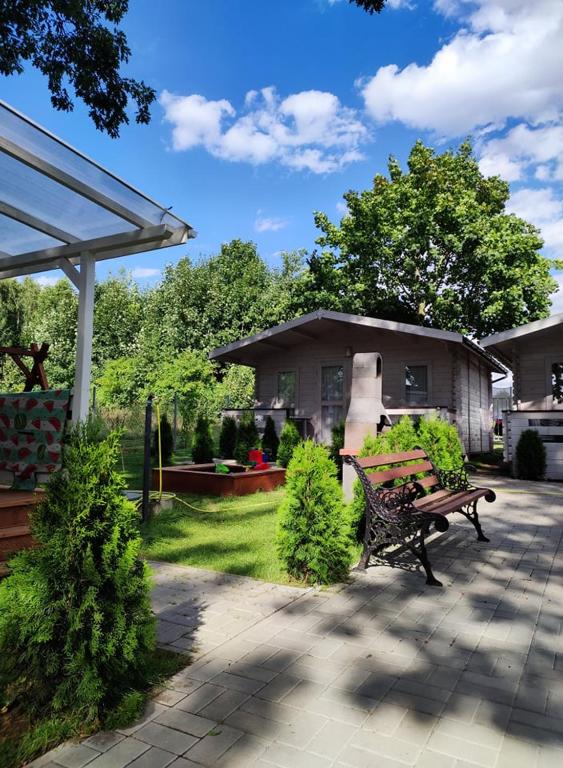 a park bench in a yard with a house at Dziwnówek DOMKI U MILENY Dziwnówek in Dziwnówek