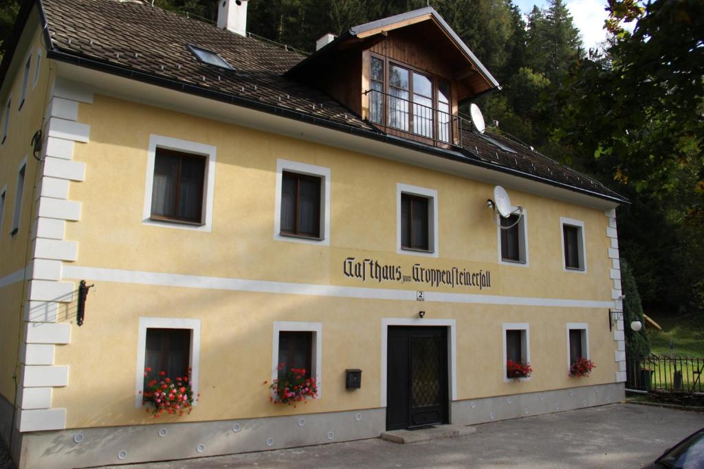 un edificio con un cartello sul lato di Groppenstein Apartmanház a Obervellach