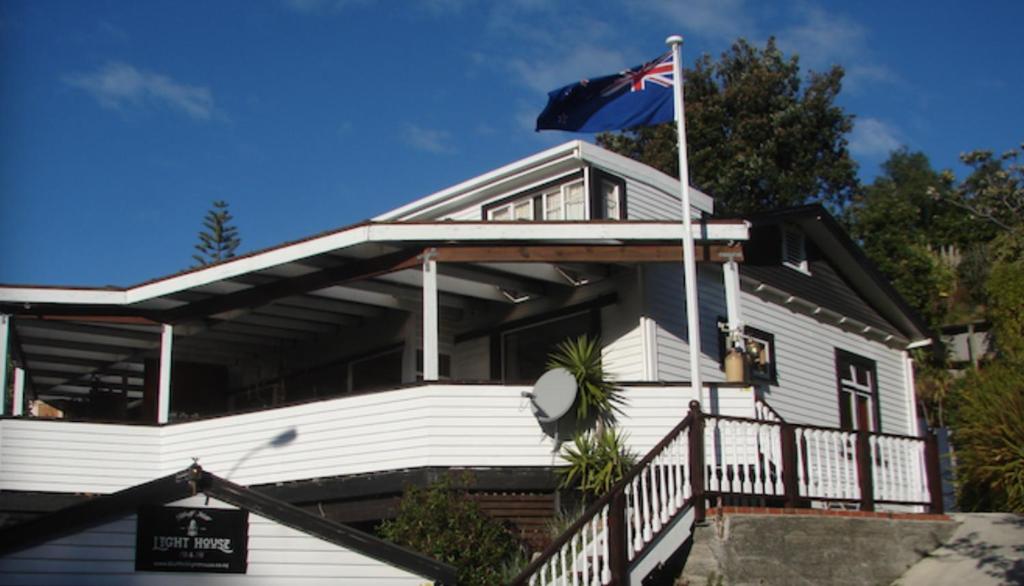 a house with a flag on the front of it at Bluff Hill Lighthouse B&B in Napier
