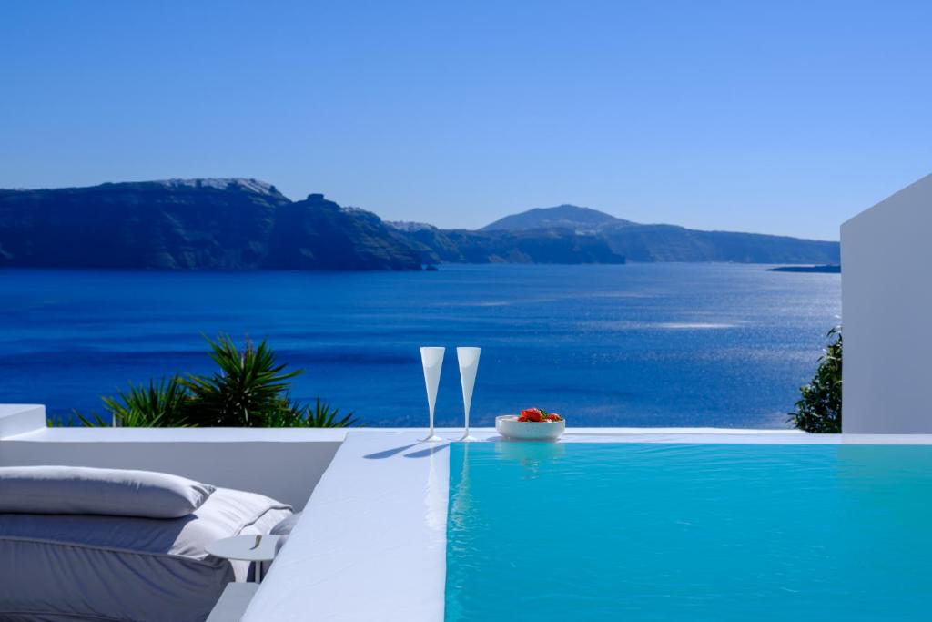 a swimming pool with a view of the water at Lathouri Cave Villa in Oia