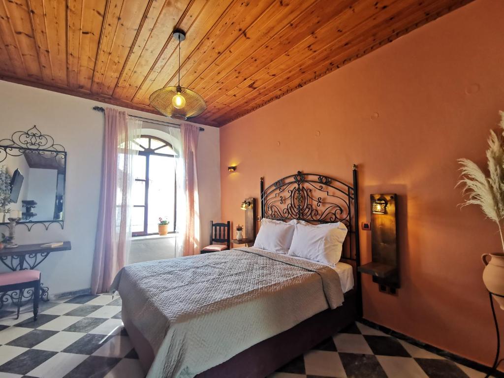 een slaapkamer met een bed en een houten plafond bij Terracotta Boutique Beach Studios in Mithimna