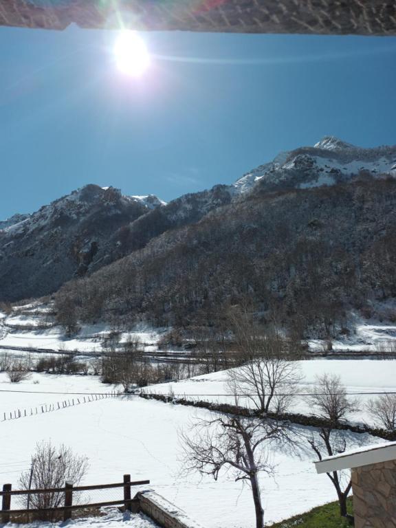 um campo coberto de neve com uma montanha ao fundo em Hotel valle de lago em Valle de Lago