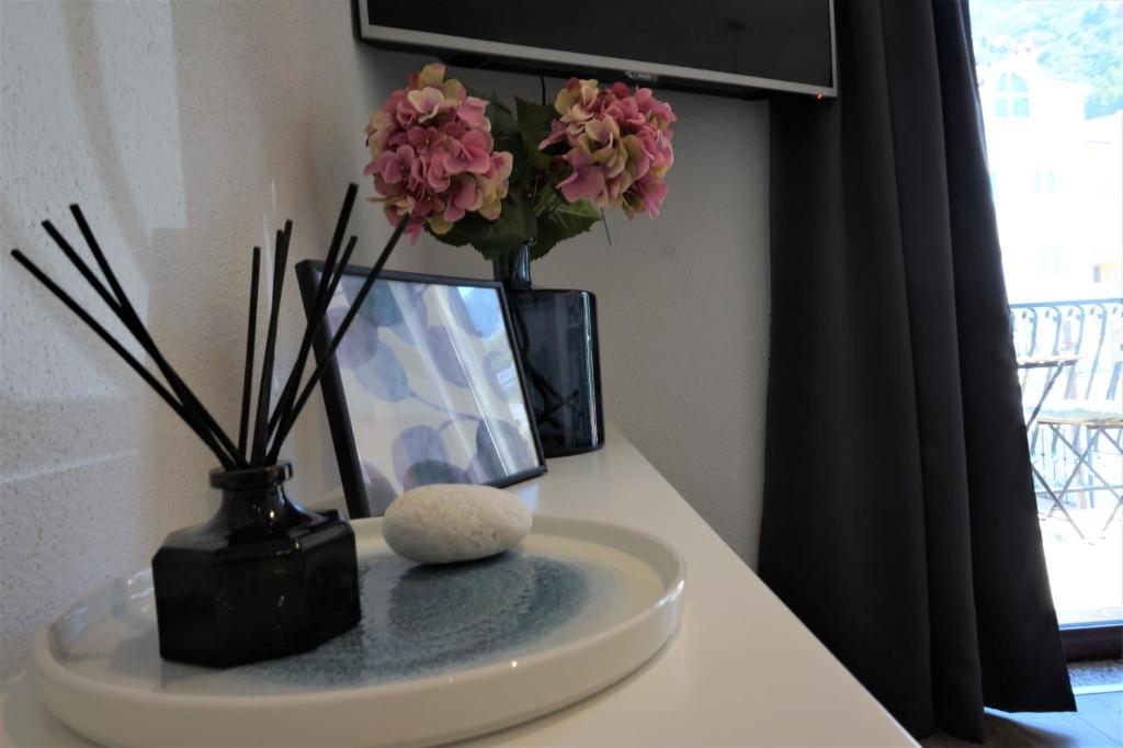 a white counter with a vase with flowers in it at Apartment Cosy & Sweet in Makarska