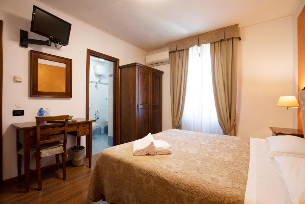 Postel nebo postele na pokoji v ubytování Hotel Arcobaleno Siena