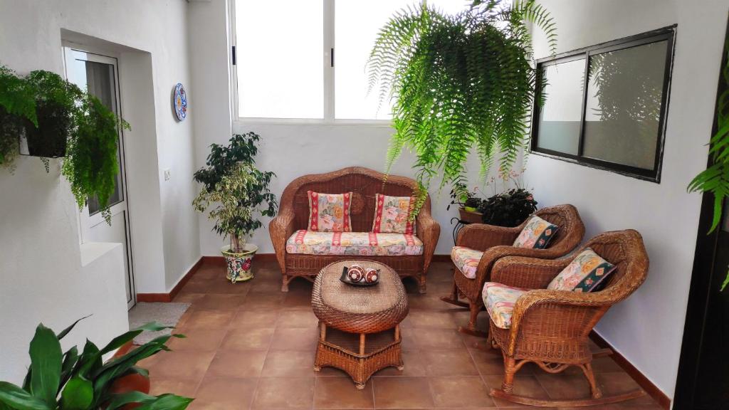 een woonkamer met rieten stoelen en een tafel bij La Orquídea in Vega de San Mateo