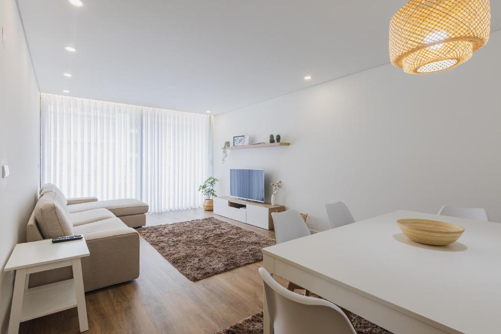 ポンタ・デルガダにあるPaim XXI Azores Apartmentの白いリビングルーム(ソファ、テーブル付)