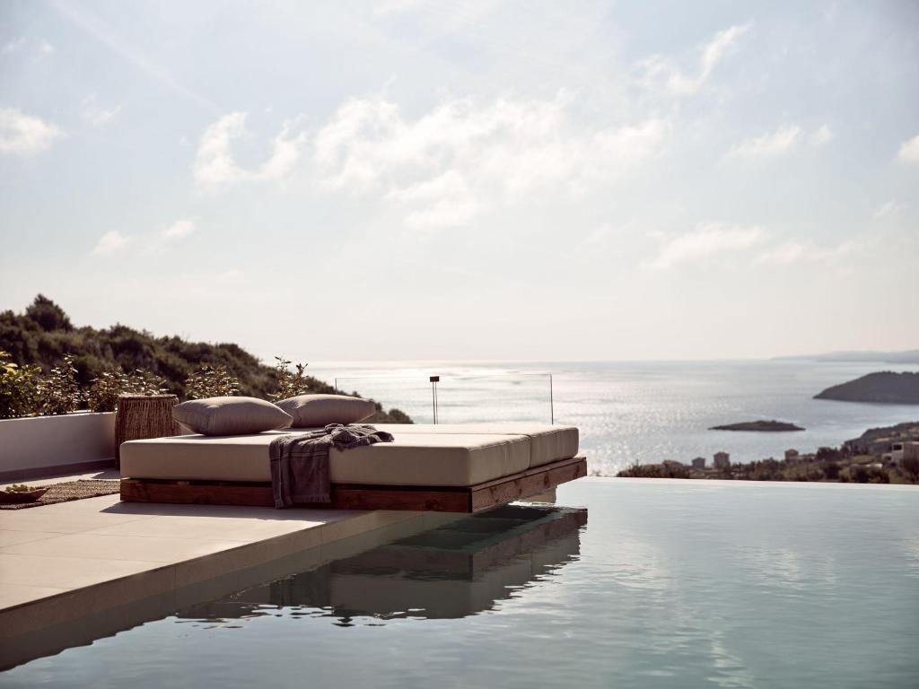 a bed sitting on the edge of a swimming pool at The Sall Suites Complex A - Iconic Sea Views, by ZanteWize in Agios Nikolaos