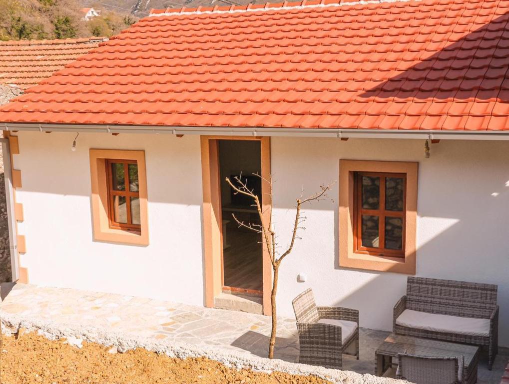a small white house with an orange roof at Apartmani Dumezic in Bar