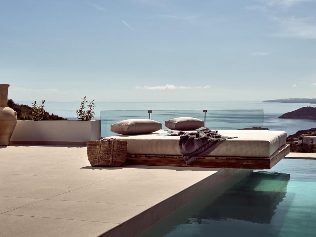 a bed sitting on the edge of a swimming pool at The Sall Suites Complex A - Iconic Sea Views, by ZanteWize in Agios Nikolaos