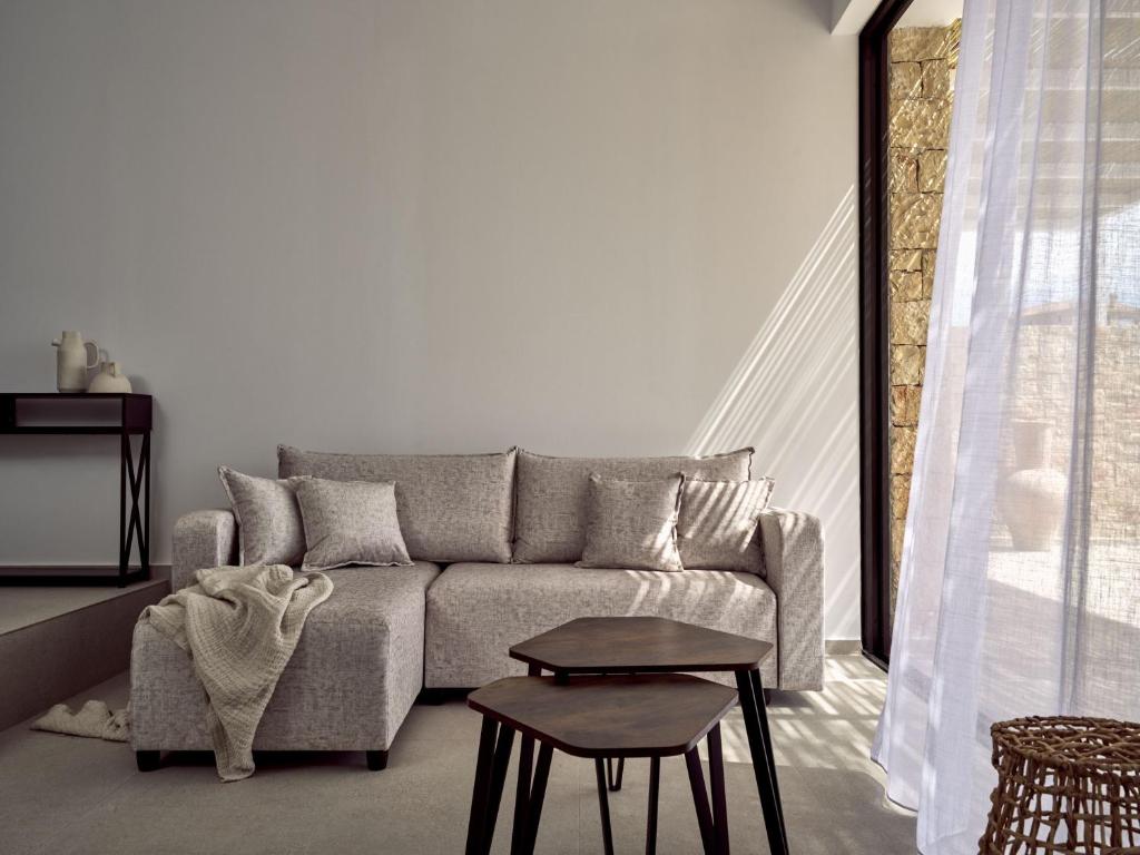 a living room with a couch and a table at The Sall Suites Complex A - Iconic Sea Views, by ZanteWize in Agios Nikolaos