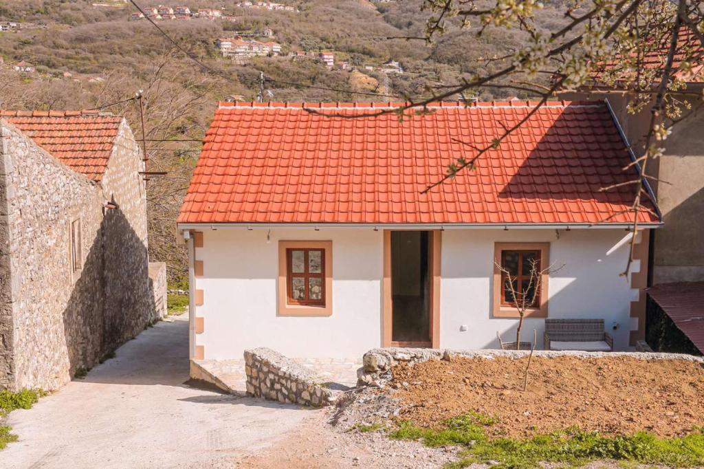 a small white house with an orange roof at Apartmani Dumezic in Bar